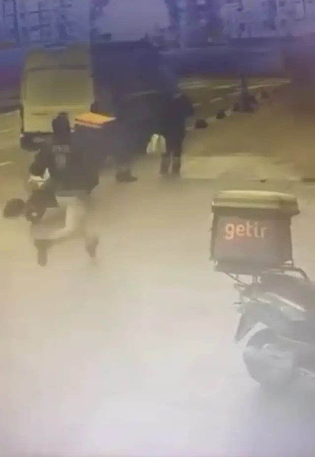 Güvenlik kamerası görüntüsünde polis memurunun motosiklete binmesi