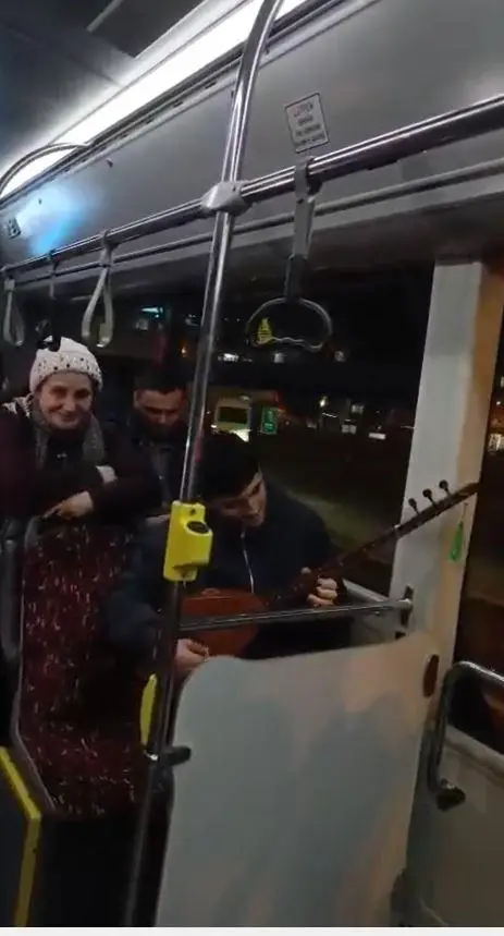 Otobüste saz çalan yolcunun yakın çekimi
